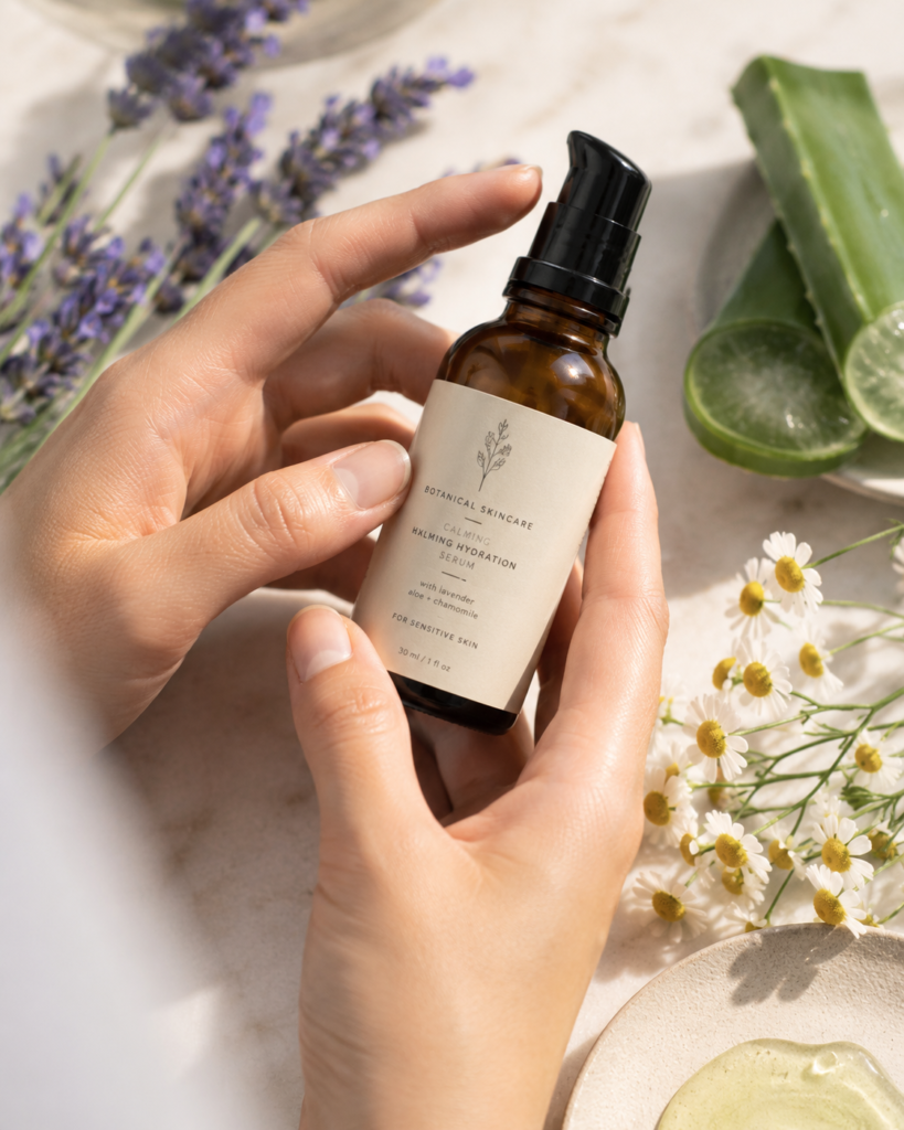 Person reading the label on a botanical skincare product before use.